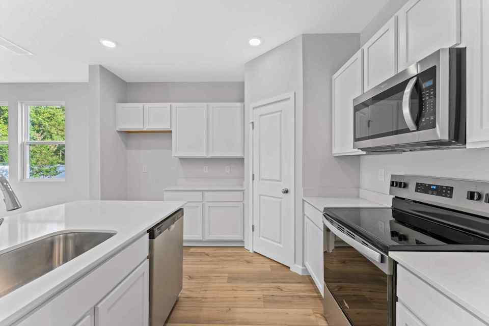 Davor Paired Home Kitchen with White Cabinets at The Landings at Pecan Park in Jacksonville