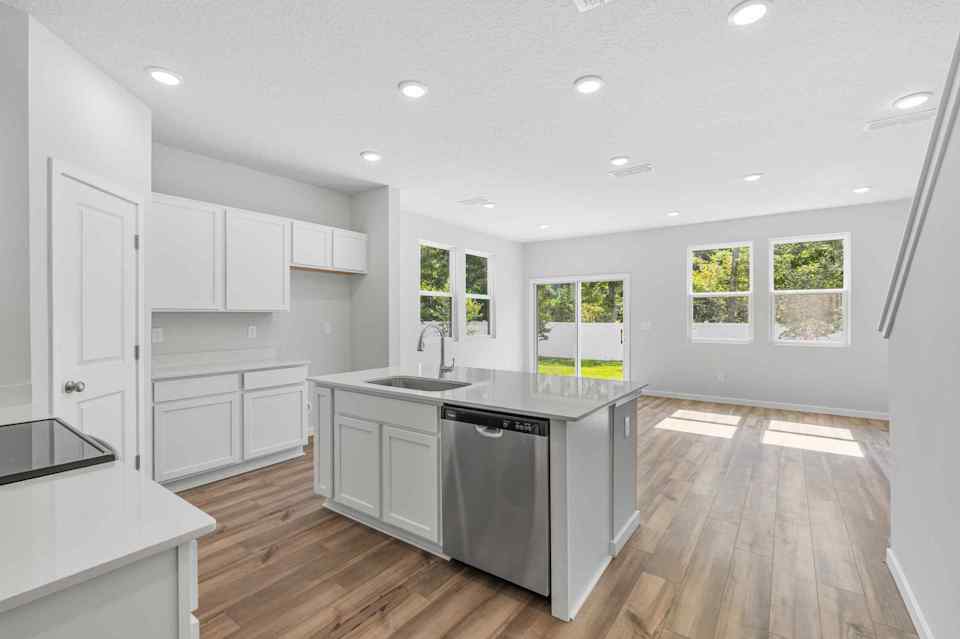 A kitchen with white cabinets.