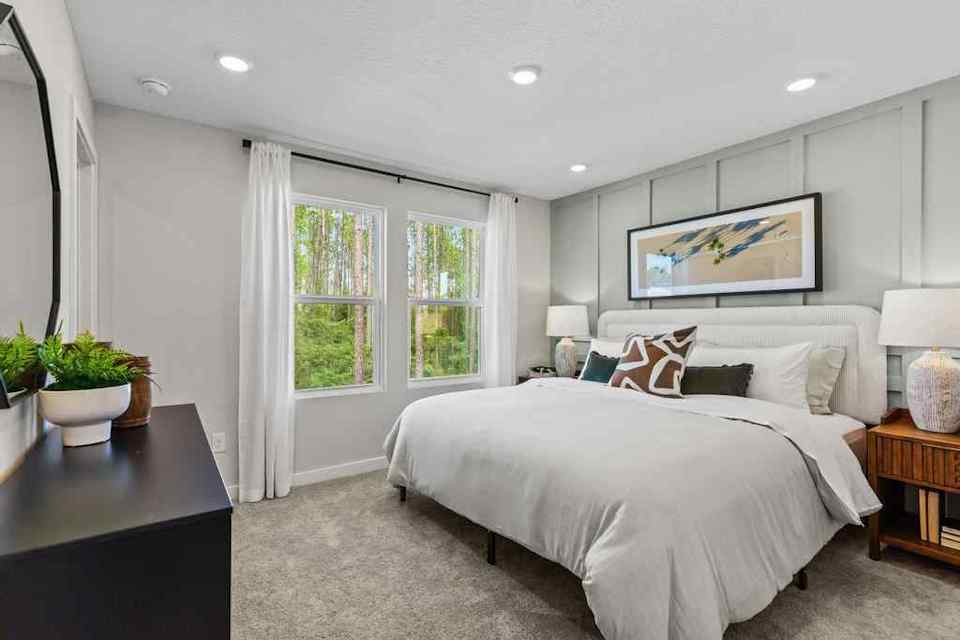 A bedroom with a bed and a table.