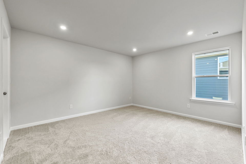 A room with a window and a carpet.