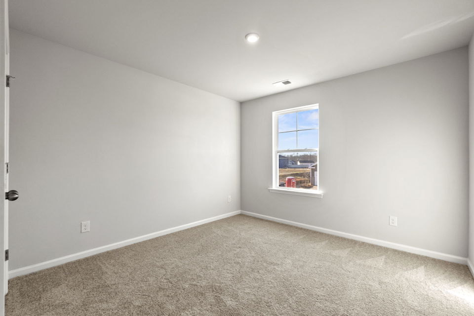 A room with a window and carpet.