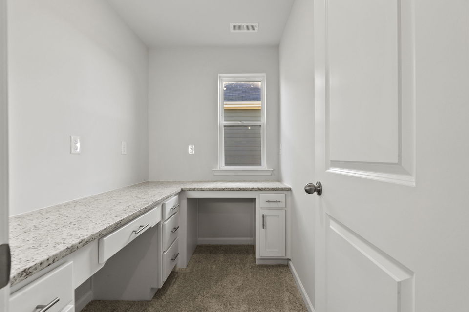 A kitchen with white cabinets.