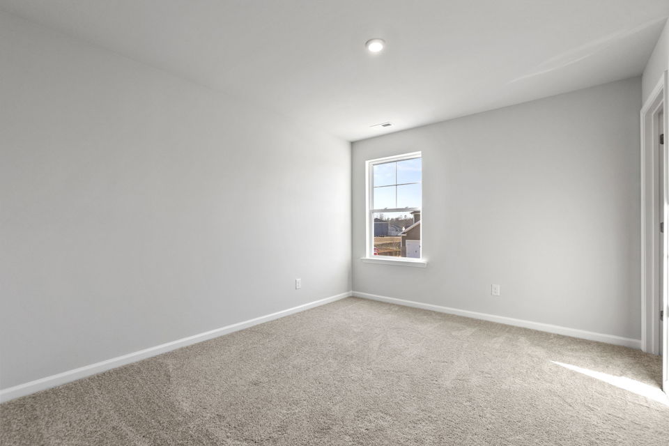 A room with a window and carpet.
