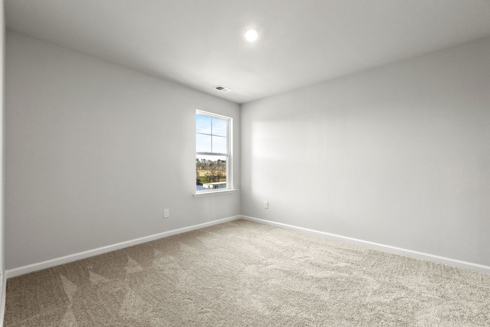 A room with a window and carpet.