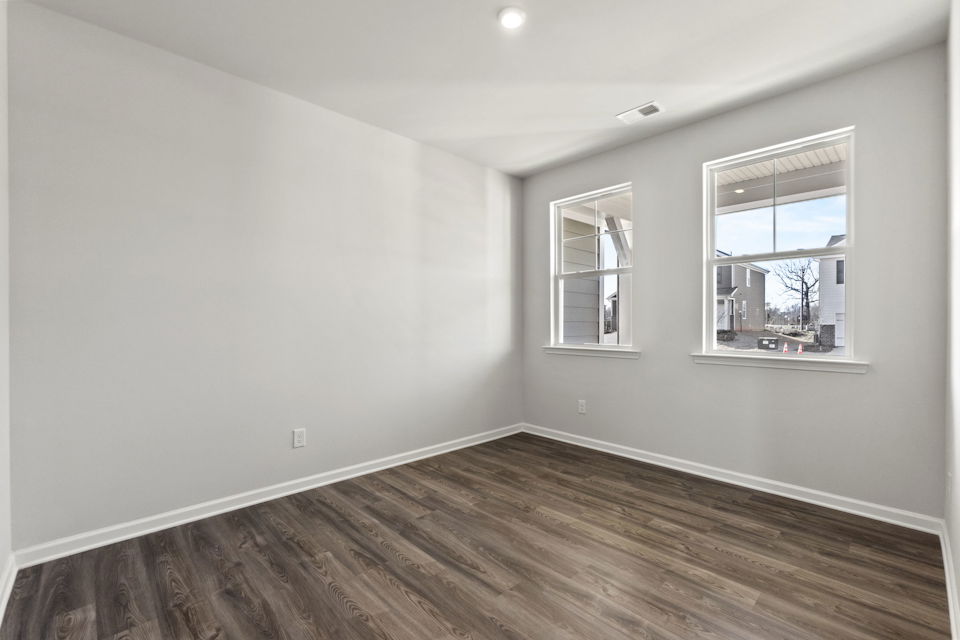 A room with a wood floor and windows.