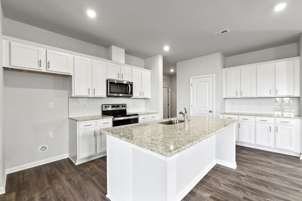 A kitchen with white cabinets.