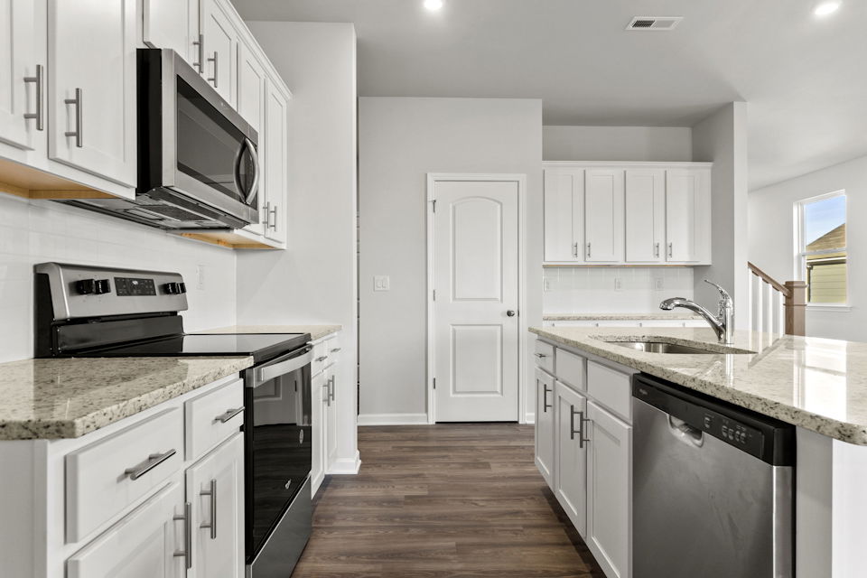 A kitchen with white cabinets.