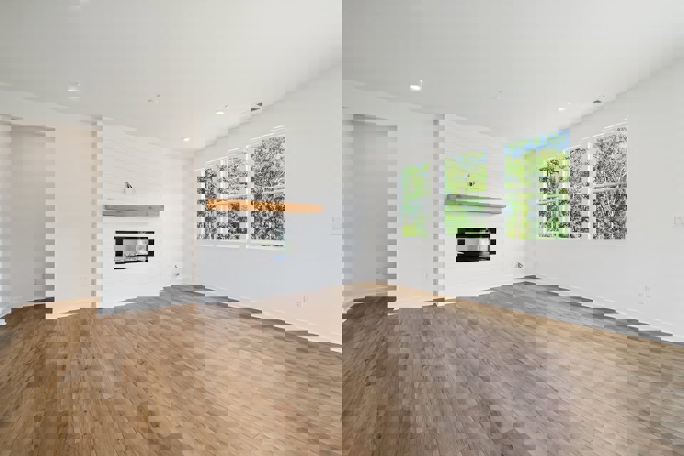 A room with a fireplace and a wood floor.