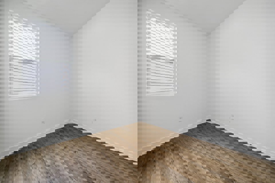 A room with a wood floor and a window.