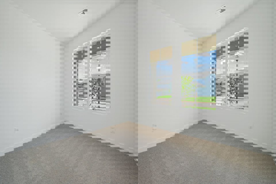 A room with a window and a door with a view of the water.