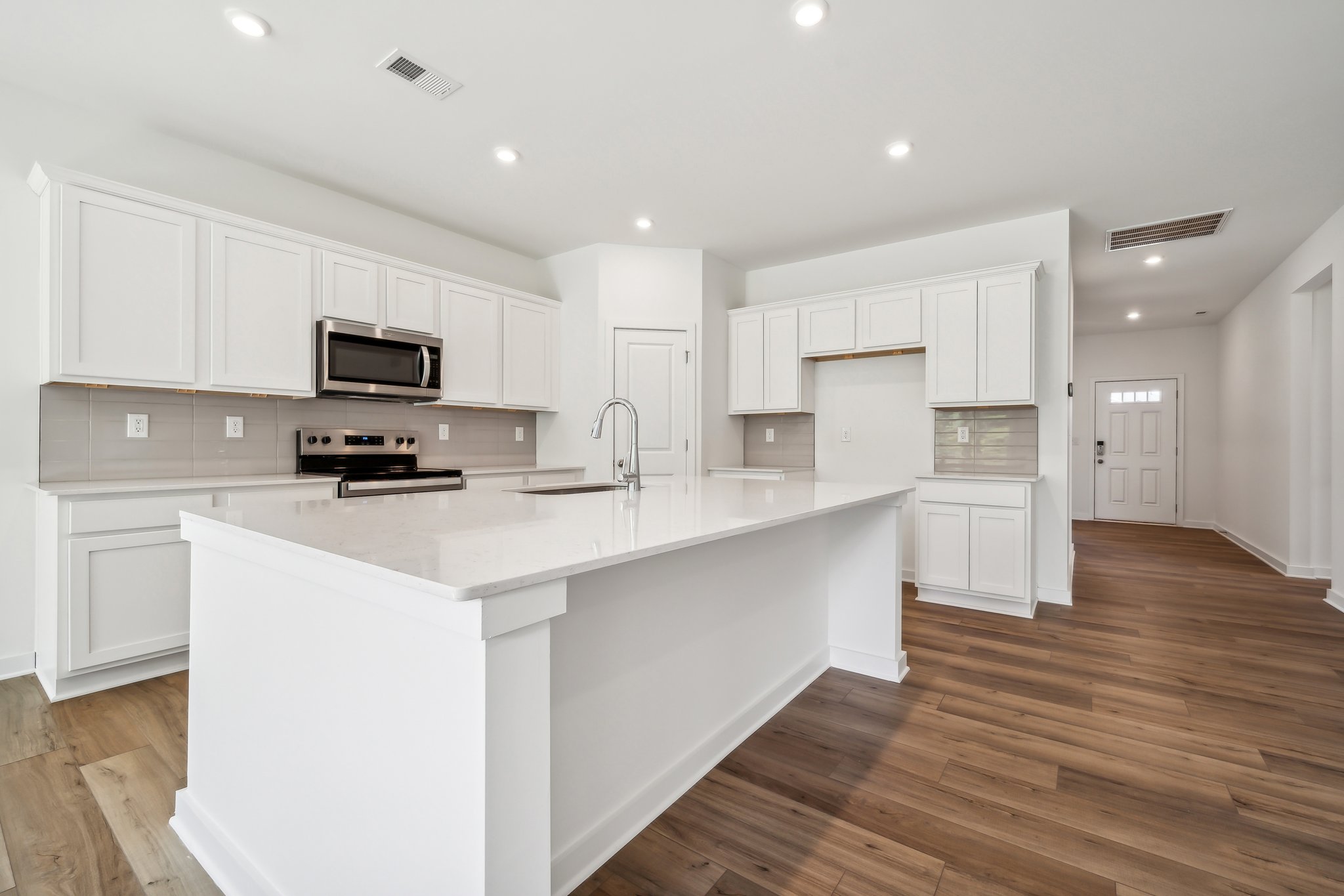 A kitchen with white cabinets.