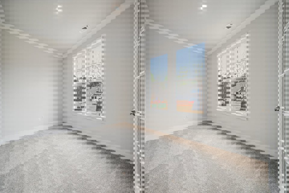 A room with a window and a carpet.