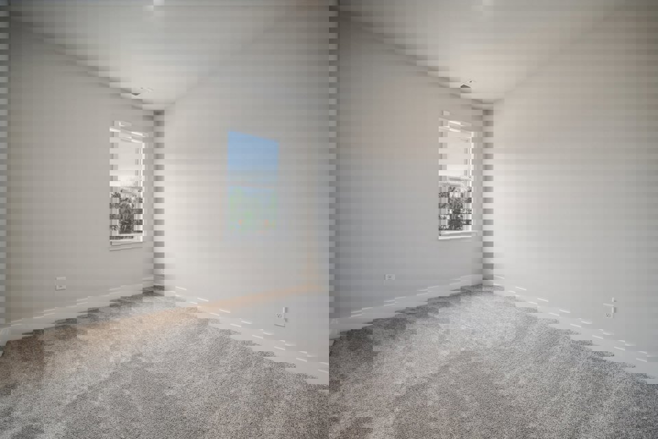 A room with a window and a carpet.