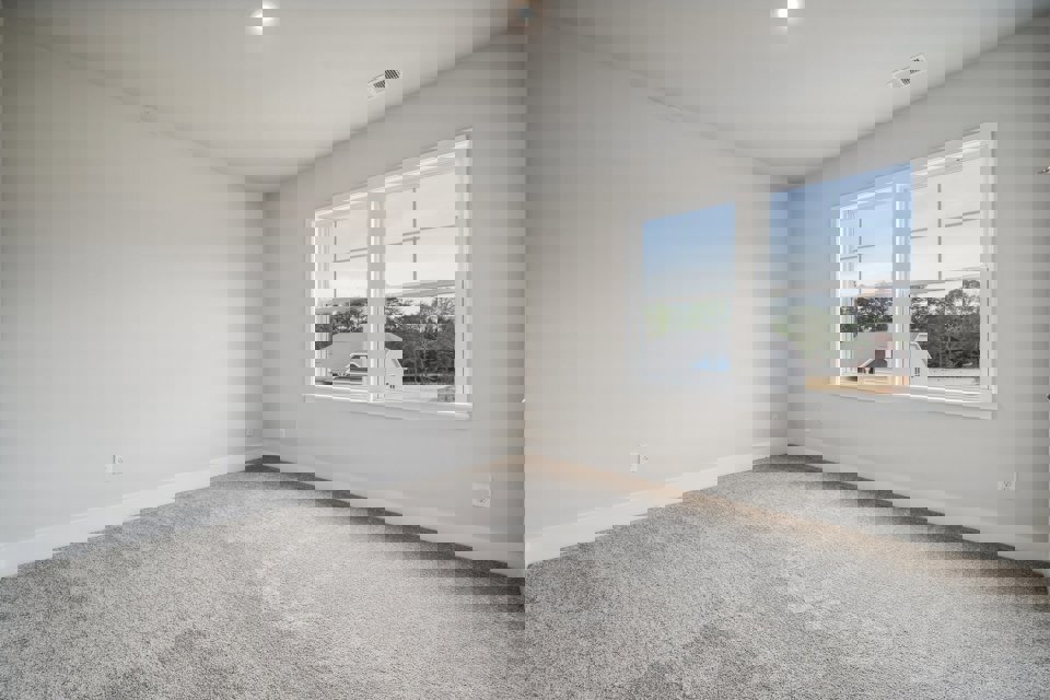 A room with a window and a white wall with a white car.