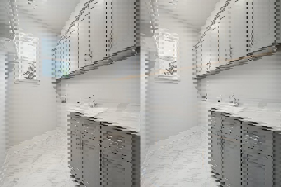 A kitchen with white cabinets.