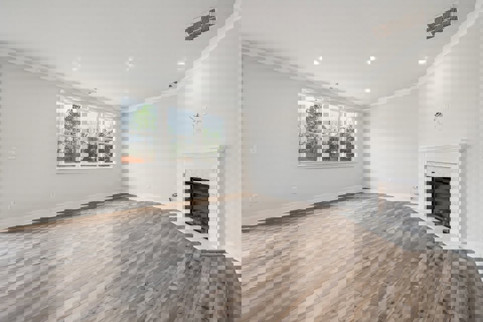 A room with a fireplace and a wood floor.