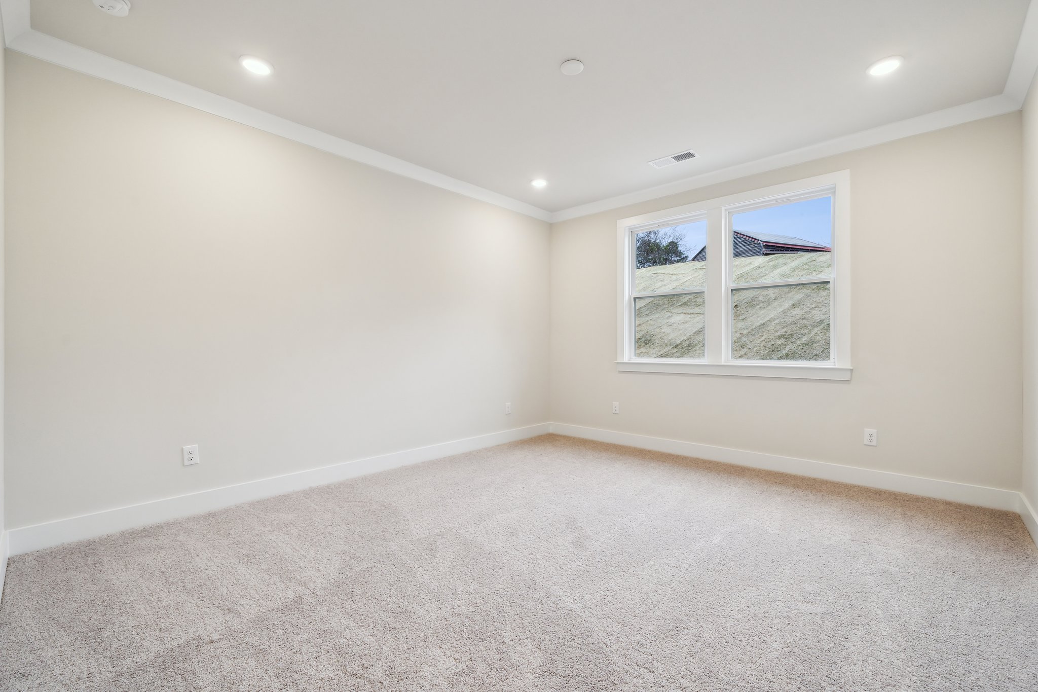 A room with a window and a carpet.
