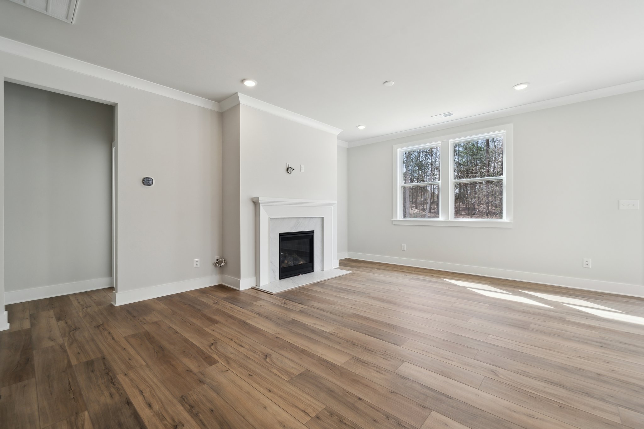 A room with a fireplace and wood floors.