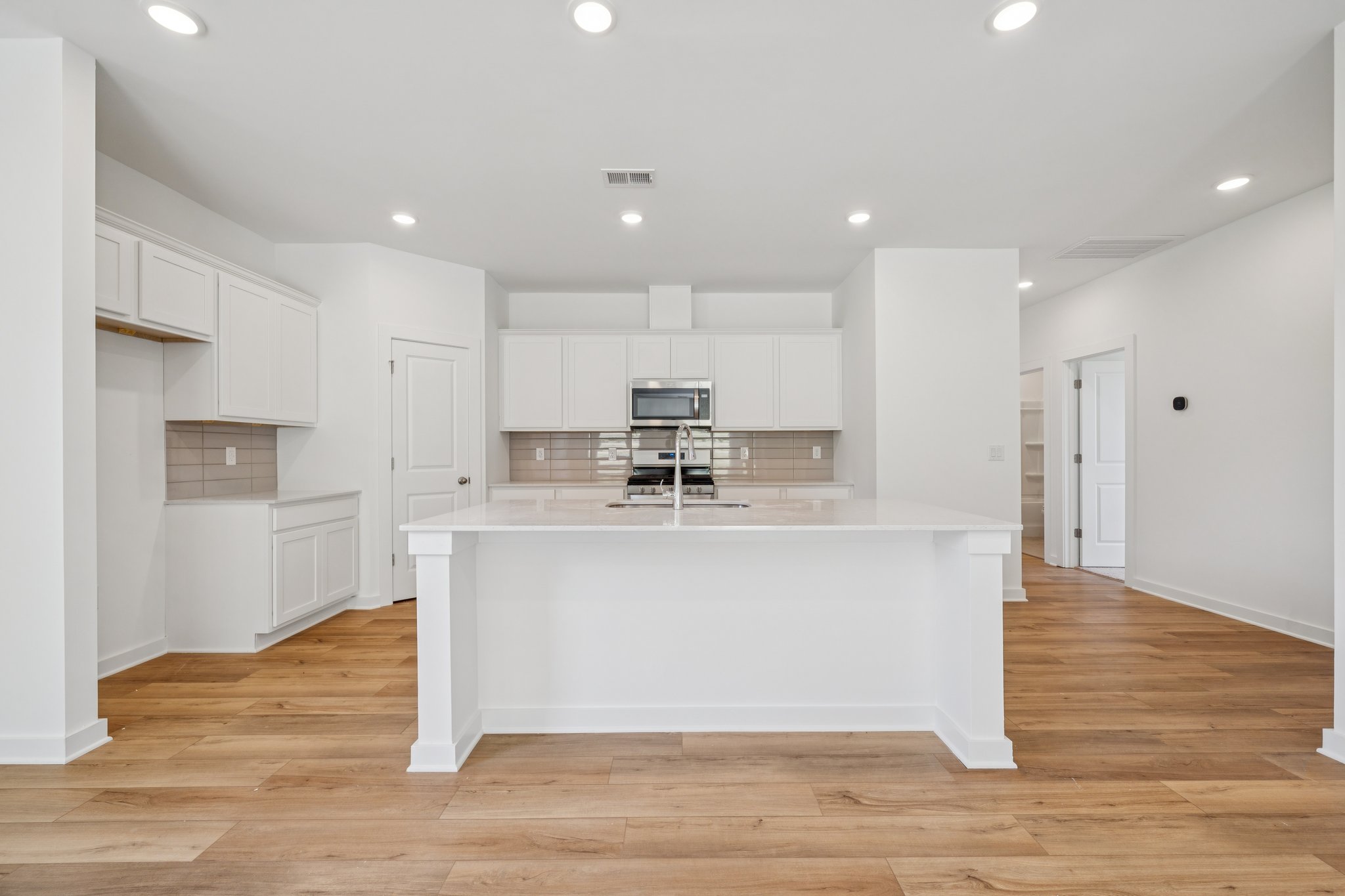 A kitchen with white cabinets.