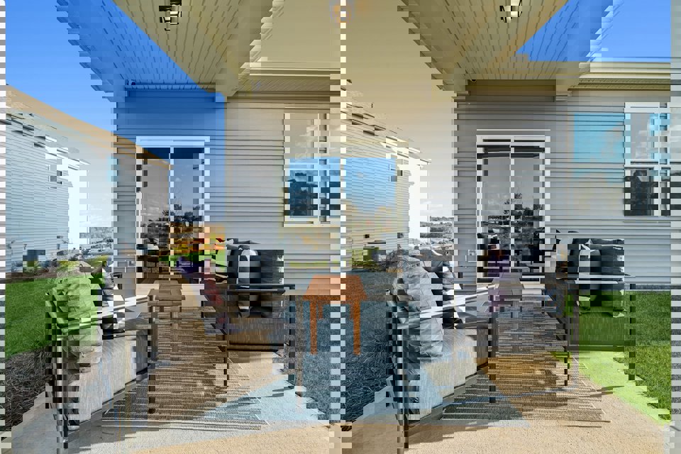 A person lying on a couch outside a house.