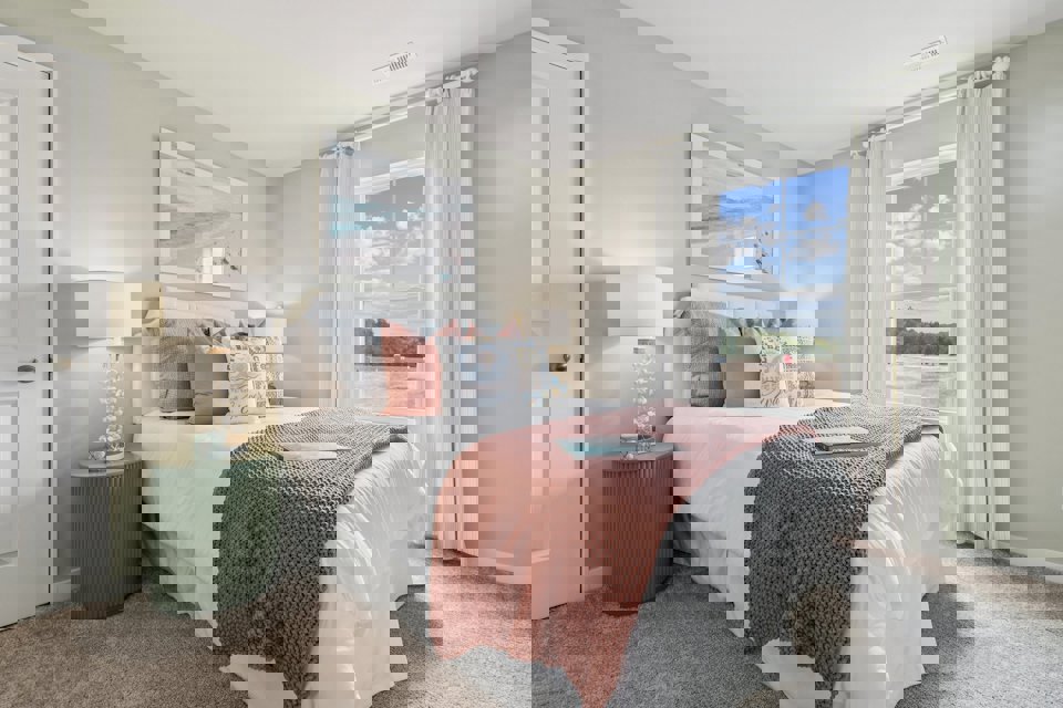 A bedroom with a large window.