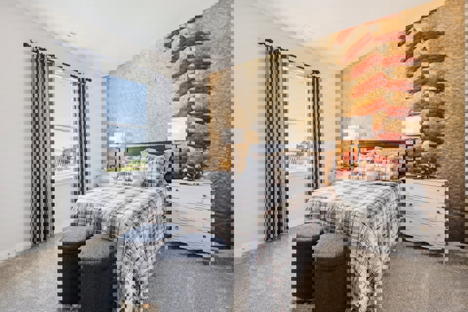 A bedroom with a bed and a window.