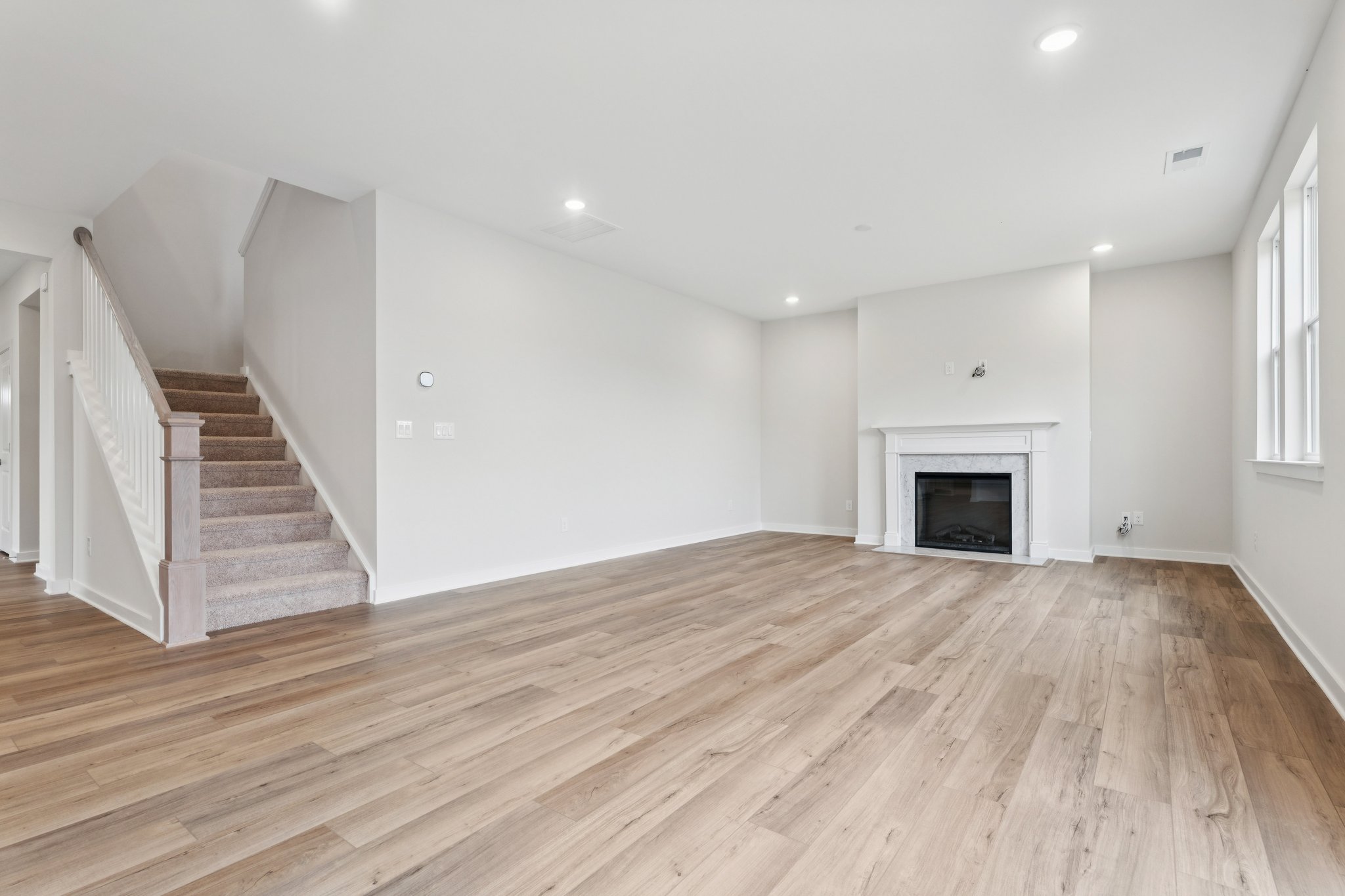 A large empty room with a fireplace.