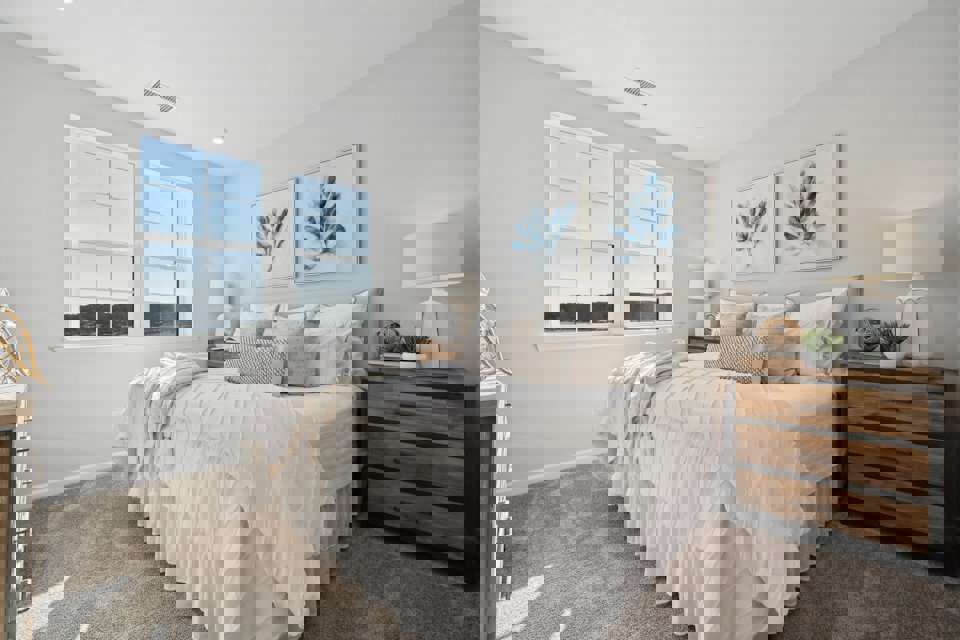 A bedroom with a bed and lamps.