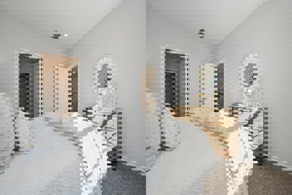 A bedroom with a bed and a table.