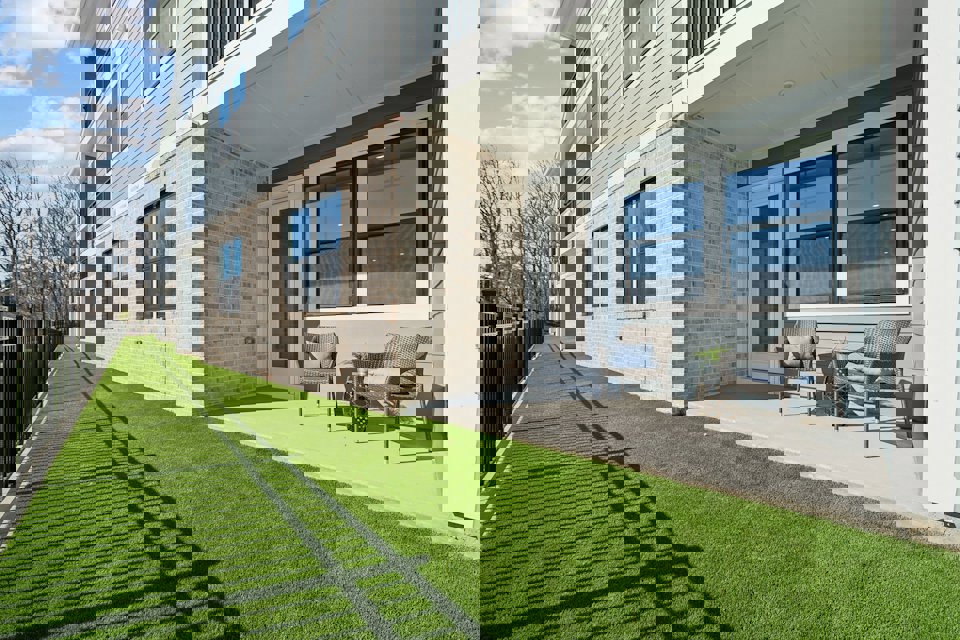 A house with a lawn and chairs.