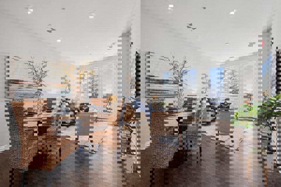 A dining room with a large table and chairs.