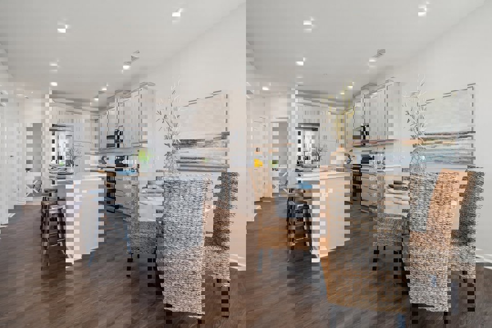 A kitchen with a dining table and chairs.