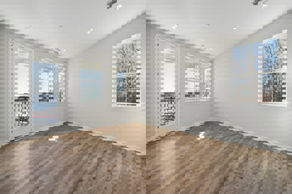 A room with a wood floor and windows.