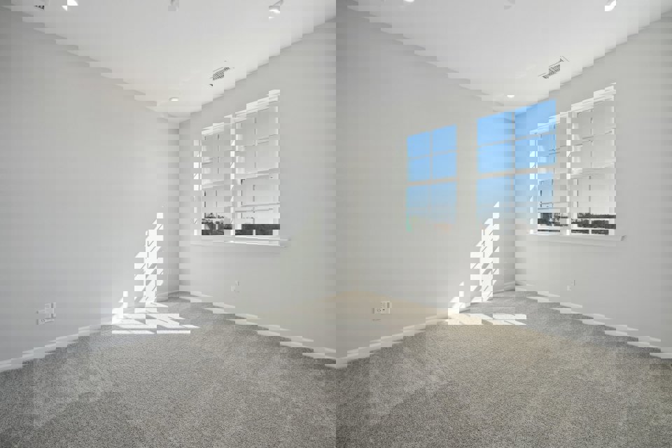 A room with a window and a carpet.