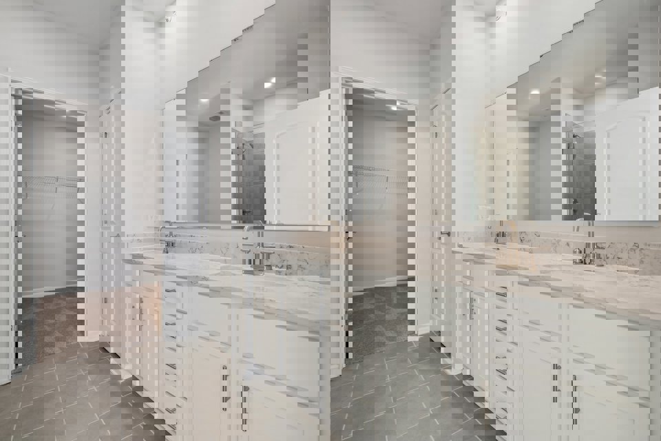 A bathroom with white cabinets.