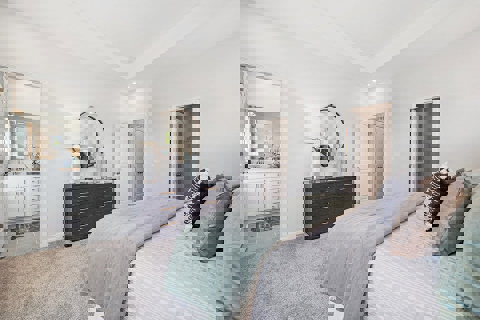 A bedroom with a bed and a mirror.