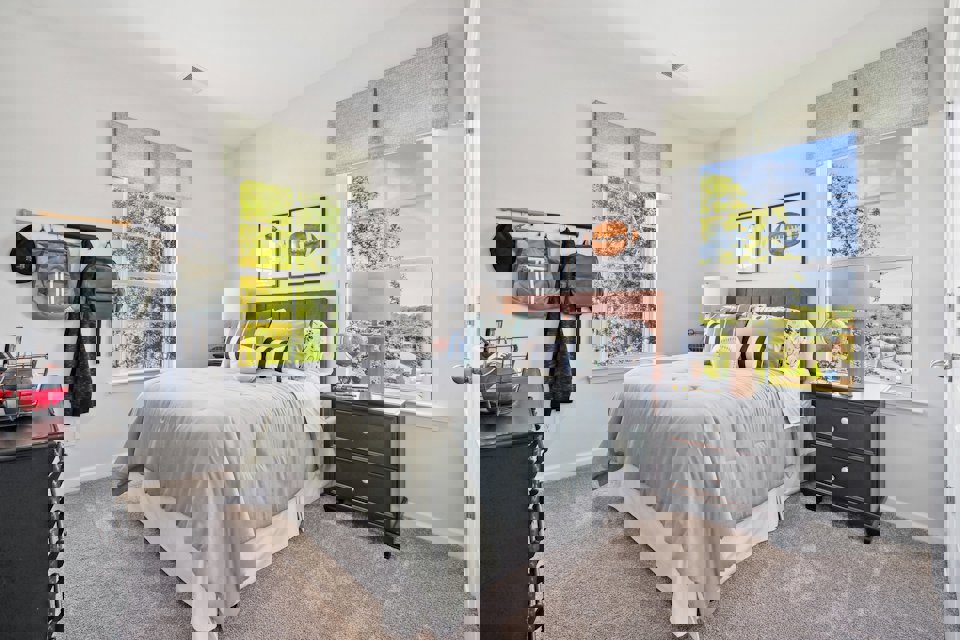 A bedroom with a bed and a window.