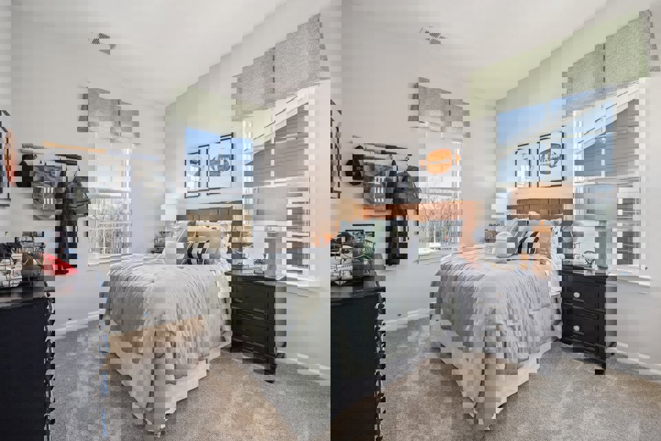 A bedroom with a bed and a dresser.