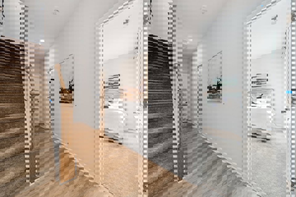 A room with a bed and a wood floor.