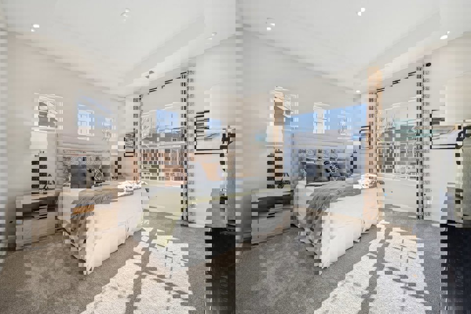 A bedroom with a large window.