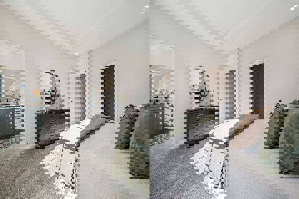 A bedroom with a bed and a dresser.