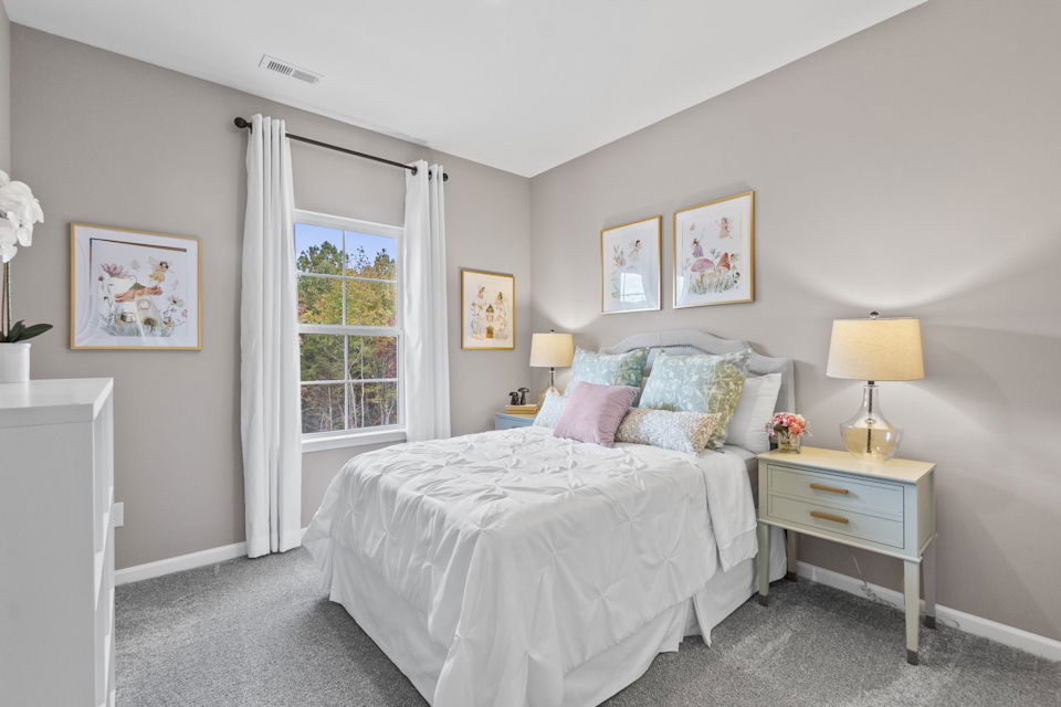 A bedroom with a bed and lamps.