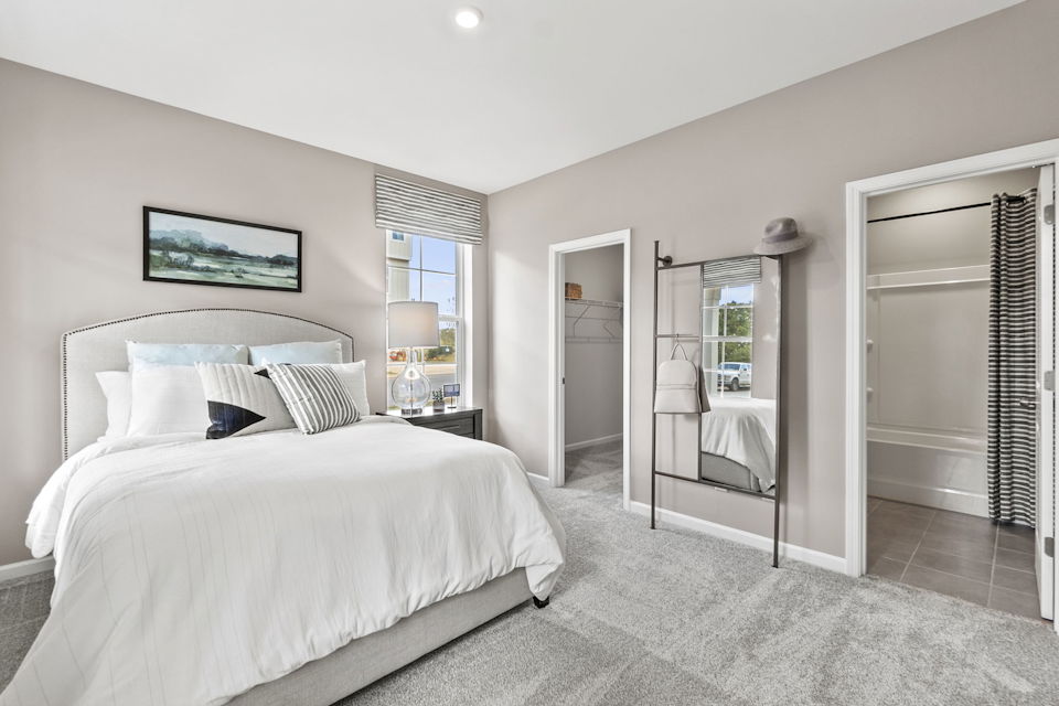 A bedroom with a large mirror.