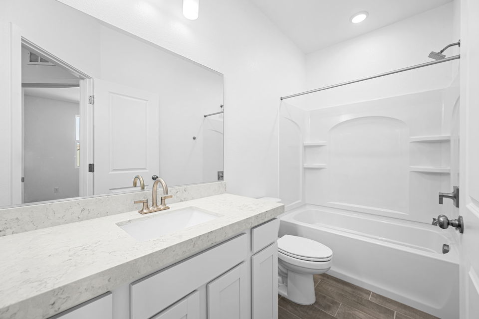 A bathroom with a tub sink and toilet.