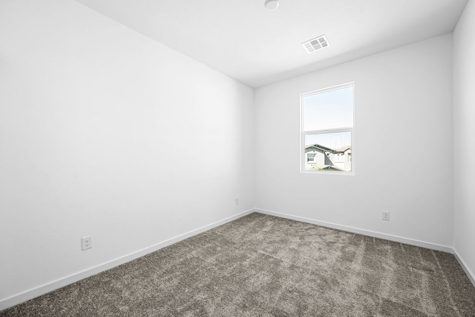 A room with a carpet and a window.