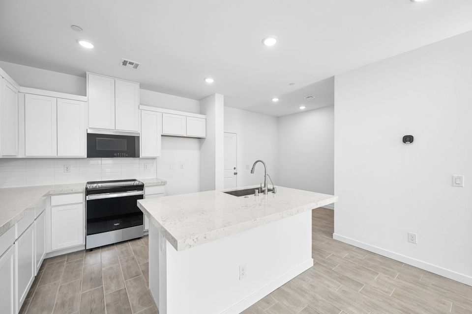 A kitchen with white cabinets.
