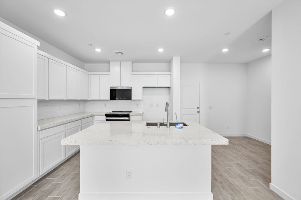 A kitchen with white cabinets.