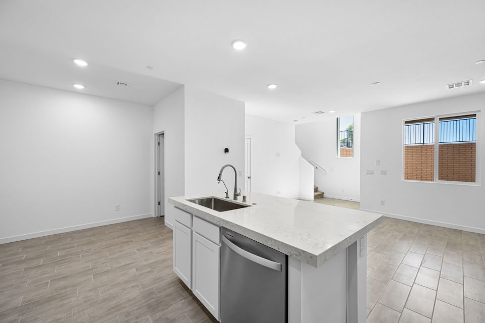 A large kitchen with a marble countertop and a sink.