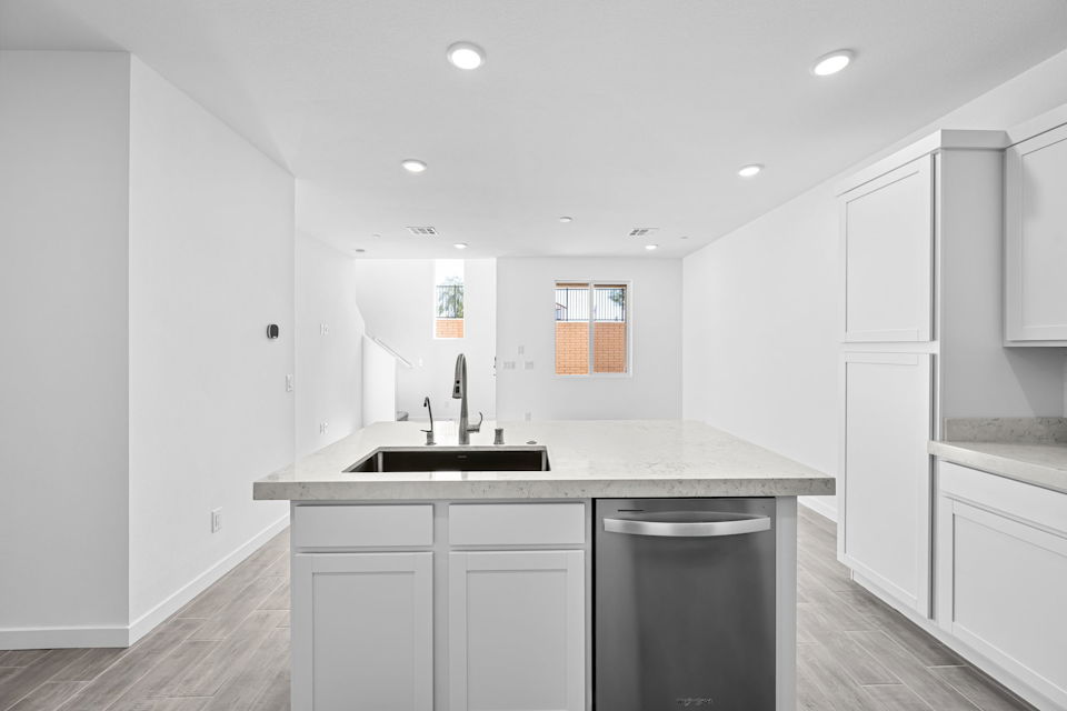 A kitchen with white cabinets.