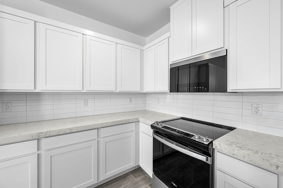 A kitchen with white cabinets.